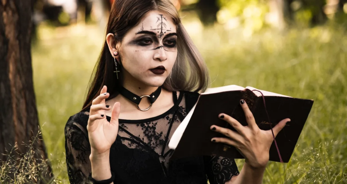 a woman with makeup on holding a book